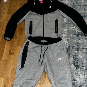 Grå och svart Nike tech  - Säljer grå svart Nike tech knappt använd. Byxorna är storlek L men det är slimfit så den passar storlek S-M bra.  Pris kan diskuteras skriv för bilder