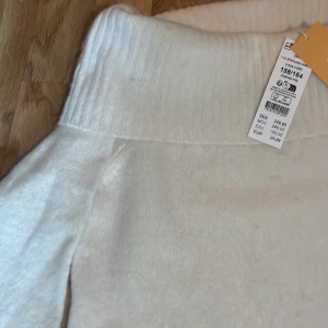 Vit offshoulder stickad tröja från Gina Tricot - Superfin vit stickad tröja från Gina Tricot med bred offshoulder-krage. Tröjan har lång ärm och ribbade muddar vid ärmslut och nederkant. Har endast testat den i butik. Kommer inte till användning för att offshoulder-krage inte passar så bra på mig. Pris kan diskuteras.