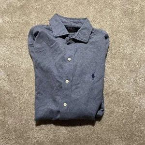 Ralph lauren skjorta i storlek M - Riktigt snygg skjorta i M passar L. Modell knit dress shirt. Grå/blå färg 