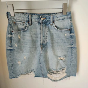 Jeanskjol  - Ljusblå jeanskjol med slitna detaljer