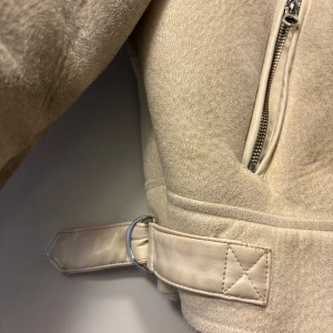Beige jacka från Stradivarius  - Säljer nu en snygg croppad jacka från Stradivarius i storlek M, Köpt på Zalando för några år sedan. Den är beige med silvriga detaljer. Två ytterfickor och fluffig, jättemjuk insida. Perfekt under lite kallare dagar.
