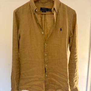 Beige linneskjorta från Ralph Lauren - Riktigt fet linneskjorta från Ralph Lauren. Använd typ 1-2 gånger. Kvitto finns för äkthets verifiering. Tags finns också. Ny pirs 1995. Mitt pris 1099 kr. Fråga frågor om du känner dig osäker. 