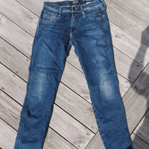 Blå Replay anbass jeans - Snygga blå jeans från Replay. Klassisk femficksdesign med raka ben och diskreta slitningar framtill. Jeansen har normal passform och är tillverkade i mjukt denimtyg med snygga detaljer på bakfickorna. Pris kan diskuteras vid snabb affär.