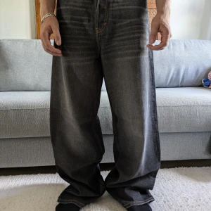 Weekday Astro Loose Baggy Jeans - Säljer ett par Weekday Astro Loose Baggy Jeans i mörkgrå tvätt. De har riktigt bred passform och baggy stil, med klassiska femficksdetaljer och kontrastsömmar. Jeansen är tillverkade i bomull och har en avslappnad, streetig vibe. Använda 1 gång Strl W29 L34