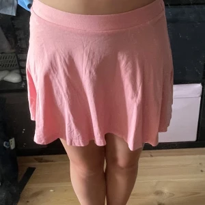 Rosa kortkjol från Ellos Kids - Supersöt rosa kortkjol från Ellos Kids i mjuk bomull. Kjolen har en enkel och flowy passform med bred resår i midjan som gör den bekväm och lätt att bära. Perfekt för dig som gillar en chill och feminin stil.