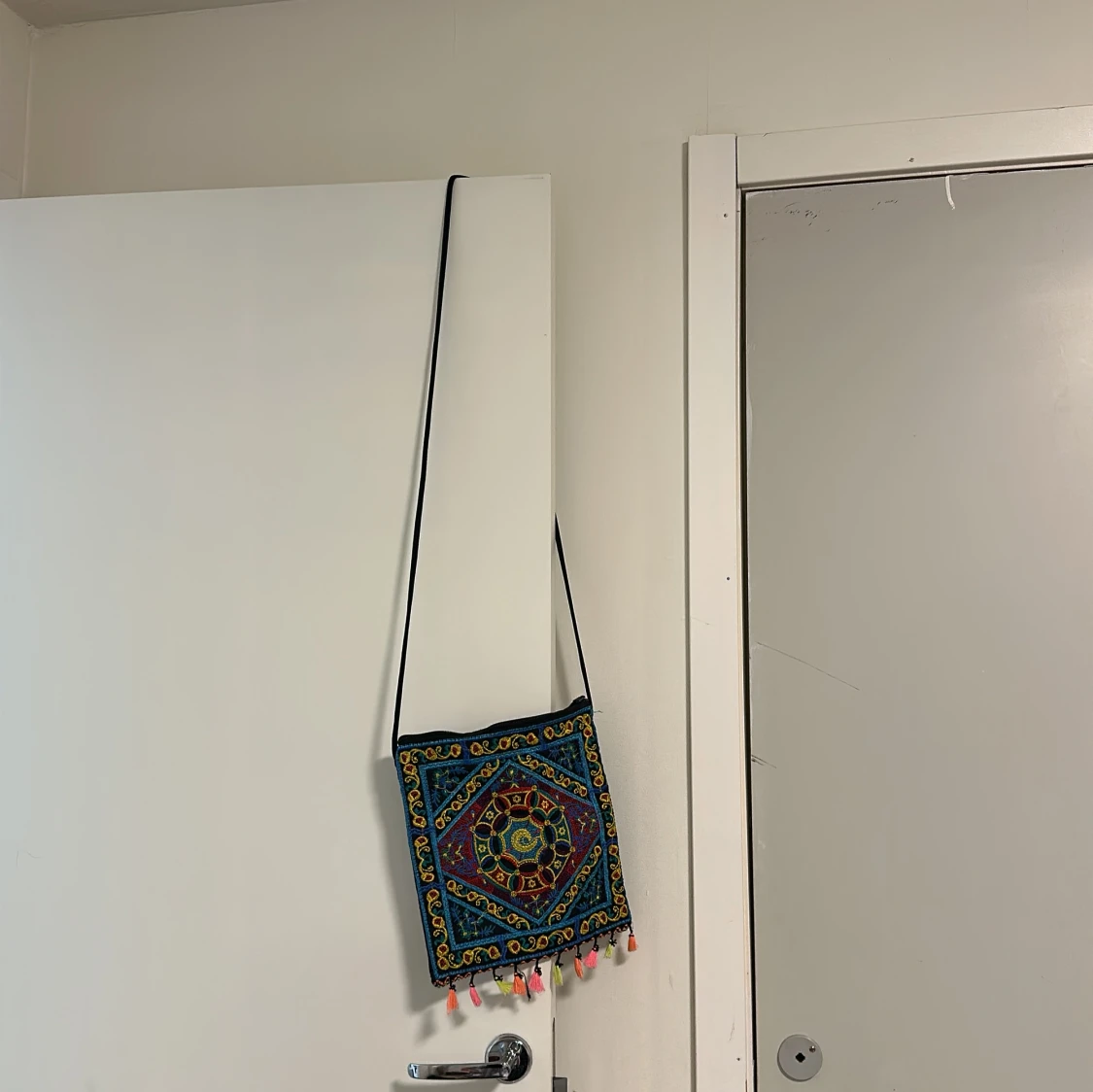 Broderad axelväska med tofsar