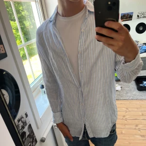 Blå vit linneskjorta  - Säljer en fräsch linne skjorta från Massimo ditto. Använd få tal gånger (typ 3 gånger) jag är 173cm tycker den passar perfekt just nu. Ny pris 700kr. Priser kan diskuteras 
