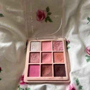 Odbo ögonskuggspalett rosa nyanser - Superfin ögonskuggspalett från ODBO med 9 olika nyanser i rosa, brunt, guld och glitter. Paletten har både matta och skimrande skuggor, perfekt för att skapa kreativa och färgstarka ögonlooks. Kommer i en söt förpackning med genomskinligt lock och rosdetalj. Packningen går av
