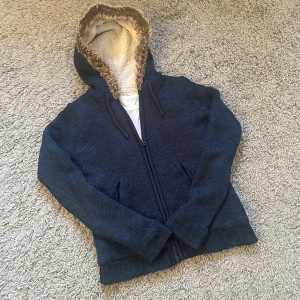 Stickad hoodie  - Säljer en riktigt snygg och skön stickad och fodrad hoodie i en as fet marinblå färg, väldigt eftertraktad. Päls på luvan 🙌Mycket bra skick, 8/10! Liten i storlek. Pris kan såklart diskuteras. Skriv vid frågor 🙏