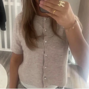 Beige stickad kofta med pärlknappar - Supersöt beige stickad kofta från 157 med kort ärm, mycket bra skick inte använda så mycket säljer pga jag rensar min garderob🤗🙌🏻