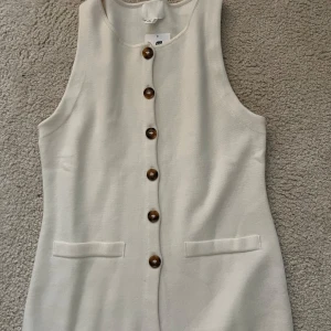 Vit väst med knappar från H&M - Jätte fin vit väst från hm. Prislappen är fortfarande kvar så den är i nytt skick