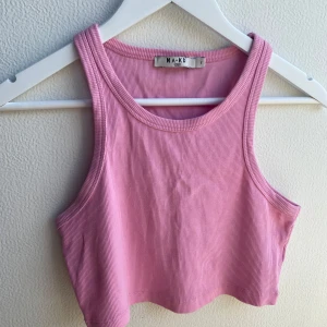 Rosa linnetopp från NA-KD - Säljer en ljusrosa croppad linnetopp från NA-KD med ribbad struktur. Perfekt till jeans eller kjol för en chill och trendig look. 