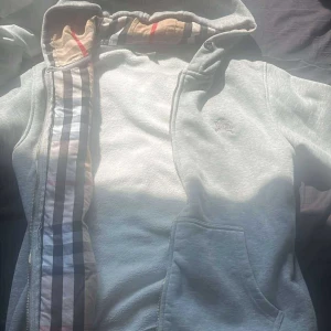 MärkesKofta grå - Grå märkeskofta, beige, vit å svarta ränder i luven. Den är i mycket bra skick, köpspris o mer info i dm.