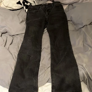Levi's Superlow Bootcut jeans svart - Svarta Levi's Superlow Bootcut jeans med låg midja och klassisk femficksdesign. Jeansen har bootcut-ben och är tillverkade i slitstarkt denim. Perfekta för dig som gillar en retro vibe och vill ha ett par snygga svarta jeans med cool passform.