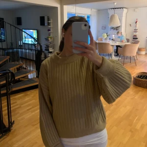 Beige ribbstickad tröja med vida ärmar - Supermysig beige ribbstickad tröja från H&M med breda, ballongformade ärmar och rund halsringning. Perfekt för lager-på-lager och chill dagar. Snygg croppad passform som ger en trendig vibe.