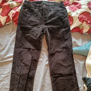 Bruna manchesterbyxor från MAC - Säljer ett par svarta manchesterbyxor från MAC. Byxorna har smal passform och raka ben, perfekt för dig som gillar en stilren look. Materialet är mjukt och ger en snygg struktur. Passar till både sneakers och boots.