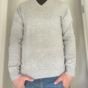 John Henric pullover - Snygg ljusgrå pullover tröja från John Henric med v-ringning och ribbade muddar. Tröjan har långa ärmar och feta armbågslappar i matchande grått. Perfekt för dig som gillar en clean och stilren look. Storlek small. Toppskick! Inga märken, defekter eller skador. Frågor eller funderingar? Bara att höra av sig!