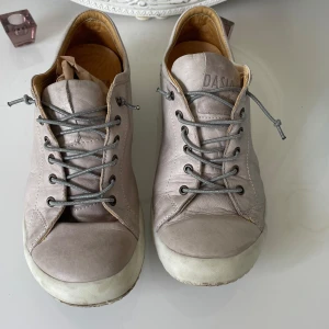 Beige sneakers i skinn från Dasia - Snygga beige sneakers från Dasia i mjukt skinn med grå snörning och vit sula. Skorna har rund tå och diskreta sömdetaljer för en clean look. Insidan är fodrad i ljust läder för extra komfort. Perfekta för dig som gillar stilrena och bekväma skor.har kostat 1300 kr 