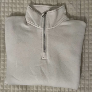 Vit half zip sweatshirt  - Vit sweatshirt med half zip. Tröjan har långa ärmar, ribbade muddar och är tillverkad i mjuk bomull. Enkel och clean stil som passar alla tillfällen. Köpt i Spanien och knappt andvänd! (Den är xs men väldigt väldigt stor i storlek passar M)🤙☺️