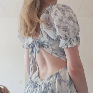 Blommig klänning med öppen rygg 🌸 - En jättefin somrig klänning som passar perfekt till midsommar. Klänningen har en smockad överdel och är därav mycket stretchig och en öppen rygg. Använd ca 3 ggr! 💕
