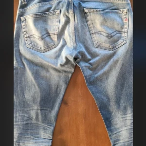 Replay ljusblå jeansbyxor herr - Snygga ljusblå jeans från Replay med klassisk femficksdesign. Byxorna har raka ben och normal passform, med Replay-logga på fickan och snygga detaljer på bakfickorna. Perfekta för en avslappnad streetstil.