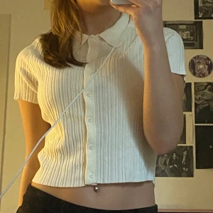Vit ribbad croppad blus med krage - Säljer en vit ribbad blus med korta ärmar och krage. 