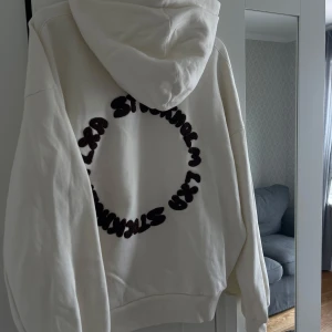 LXA-hoodie - Säljer en cremevit hoodie från LXA med brun broderad text på ryggen. Strl:M, använd 1 gång. Säljs inte längre. 