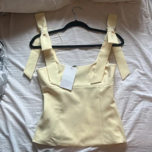 Gul topp med rosettband från Zara -  Säljer den är jättefina gula toppen Från Zara Då den är för stor för mig den är aldrig använd och har lappen kvar❤️ Skriv till mig innan ni köper