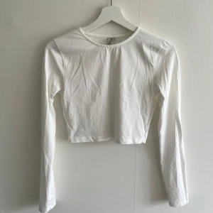 Vit långärmad tröja från Nelly - Vit långärmad tröja i croppad modell från Nelly. Använd fåtal gånger.