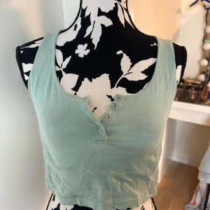  mint grön croptop - En mintgrön croptop som tyvärr inte blir använd längre. Jätte skön och har knappar vid bysten om man vill. Köpt i hawaii