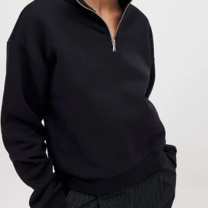 Svart half zip sweatshirt från NA-KD - Svart sweatshirt från NA-KD med halv dragkedja och hög krage. Tröjan har en relaxed passform, långa ärmar och ribbade muddar. Perfekt att slänga på sig till jeans eller dressade byxor. Materialet är mjuk bomullsmix som känns skön mot huden.