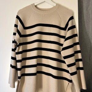 Beige och svart randig stickad tröja - Säljer en beige stickad tröja från Object i storlek XS med svarta horisontella ränder. Tröjan har rund halsringning och långa ärmar, perfekt för dig som gillar en chill och stilren look. Passar snyggt till jeans eller kjol. Tröjan är i en längre modell❤️