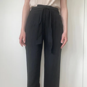 Svarta kostymbyxor Massimo Dutti - Stilrena svarta kostymbyxor från Massimo Dutti med knytband i midjan. Byxorna har raka ben och en klassisk passform. Har krympt i tvätt så passar nu xxs/32. Mycket bra skick