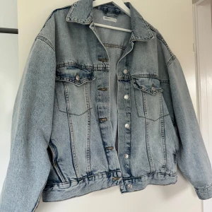 Oversized ljusblå jeansjacka Perfect Jeans - Säljer en oversized ljusblå jeansjacka från Gina tricot. Jackan har klassisk krage, knäppning framtill med silvriga knappar och två bröstfickor med lock. 