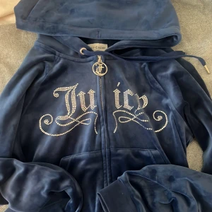 Blå velourjacka Juicy Couture S - Mörkblå velourjacka från Juicy Couture med huva och glittrande strasstenar som bildar texten 'Juicy' på bröstet. Aldrig andvänd. 💙