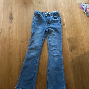 Levi's bootcut jeans ljusblå - Ljusblå Levi's jeans med klassisk femficksdesign och bootcut-ben. Jeansen har Levi's ikoniska röda etikett på bakfickan och läderpatch i midjan. Tillverkade i slitstarkt denim med snygga kontrastsömmar. Perfekta för en avslappnad och trendig look.