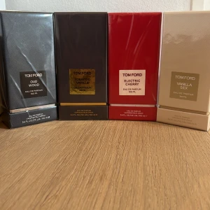 Tom Ford parfym 4-pack 100ml - Säljer fyra exklusiva Tom Ford Eau de Parfum: Oud Wood (svart), Tobacco Vanille (mörkbrun), Electric Cherry (röd) och Vanilla Sex (beige). Alla flaskor är 100 ml och kommer i snygga, lyxiga kartonger. Perfekt för dig som vill ha flera ikoniska dofter i samlingen.