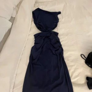 Marinblå tvådelat set med off shoulder top och långkjol  - Säljer en marinblå långkjol och off shoulder-top i ett set. Kjolen och tröjan är sydda så de ska sitta åt mer i midjan och på höften, annars skönt luftigt material. Sista bilden är hur den ser ut på modelen.