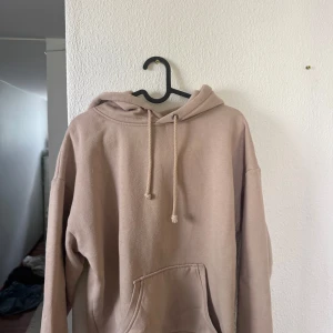 Beige hoodie från BikBok - Säljer en oversized beige hoodie från BikBok i storlek XS. Tröjan har huva med dragsko och en stor magficka framtill. Perfekt för en avslappnad stil och enkel att matcha med det mesta.