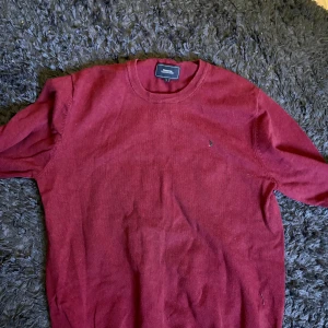 Vinröd tröja från Boomerang - Vinröd tröja från Boomerang i klassisk modell med rund halsringning. Tillverkad i mjukt material, perfekt för kyligare dagar. Diskret logga på bröstet och ribbade muddar vid ärmslut och nederkant. Storlek M i väldigt bra skick 