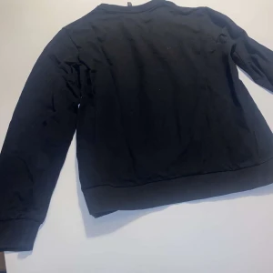 Svart ziptröja från Emporio Armani EA7 - Säljer en svart ziptröja från Emporio Armani EA7. Tröjan har hel dragkedja framtill, ståkrage och diskret logga på bröstet. Perfekt för en stilren och sportig look. Materialet är mjukt och bekvämt. Den är S men funkar bra till XS storlek.