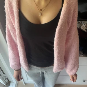 Ljusrosa stickad kofta från Lindex - Mysig ljusrosa stickad kofta från Lindex i storlek XS/S. Koftan har en lös passform och långa ärmar. Perfekt att slänga på sig över en topp för en chill look.