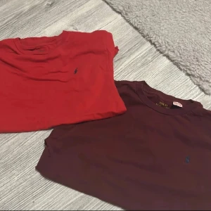 Två t-shirts från Polo Ralph Lauren - Säljer två klassiska t-shirts från Polo Ralph Lauren. En är röd och den andra är vinröd, båda med broderad logga på bröstet. T-shirtsen har rund hals och korta ärmar, perfekta för en avslappnad stil. Storlek 170