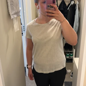 Vit topp med svarta prickar - En vit topp med svarta prickar. En topp som är perfekt för att klä upp vardagen lite. Toppen är stretchig och i ett skönt material