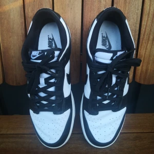 Nike Dunk Low svartvita sneakers - Nike Dunk Low sneakers i svart och vitt. Skorna har svart snörning, rund tå och platt sula. 
