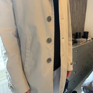 Beige rock från Tiger of Sweden - Säljer en stilren beige rock från Tiger of Sweden. Jackan har klassisk rak passform, knäppning med stora knappar framtill och två sidfickor. Perfekt för dig som vill ha en tidlös och snygg jacka till garderoben. Den är välanvänd! Vid intresse skicka privat då det finns defekter! 