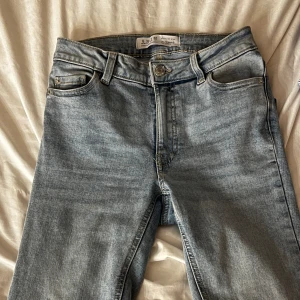 Ljusblå bootcut jeans - Säljer ett par ljusblå jeans med bootcut ben från primark. Använda endast 1 gång, Jeansen har tight passform och är tillverkade i denim med knapp- och dragkedjegylf. Perfekta för en avslappnad stil.
