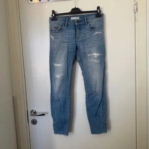 Odd molly jeans  - Säljer ett par blåa jeans med slitningar på framsidan och dragkedjor vid bensluten. Jeansen har klassisk femficksdesign och knappgylf. Perfekta för en avslappnad och trendig look. Från märket Odd Molly i storlek W25 som kanske motsvarar runt en XS. Fint skick, något mer använda. 