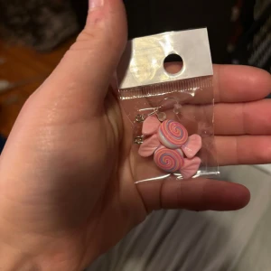 Söta örhängen med godisdesign - Supergulliga örhängen formade som godisar i rosa och lila toner. Perfekta för dig som vill ha något lekfullt och färgglatt till din stil. Säljs i originalförpackning och är ett riktigt statement-accessoar!