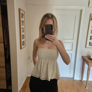 Glittrig tubtopp med volang - Säljer en söt glittrig tubtopp med volang från gina tricot. Toppen är axelbandslös och har en luftig, flowy passform nedtill. Perfekt för varma dagar och enkel att styla💘💘